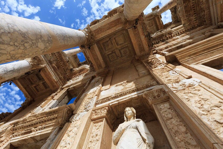An ancient stone structure with intricate carvings and a statue. 1
