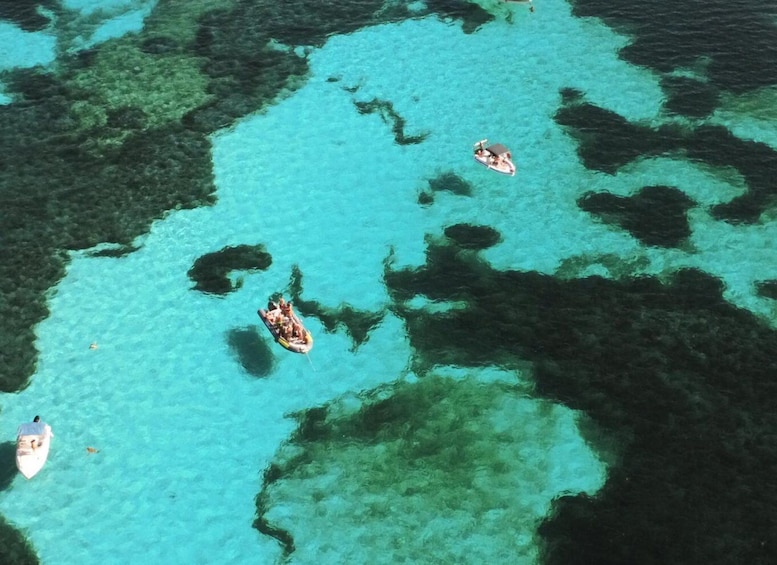 A clear turquoise sea with several boats anchored. 1