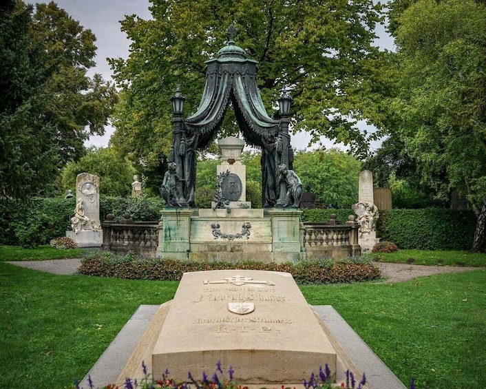 A garden with a central monument, surrounded by lush greenery and statues. 4