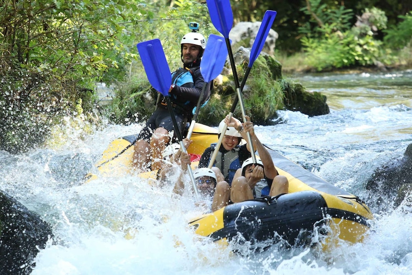 A group of people rafting on a river, navigating through rapids. 1