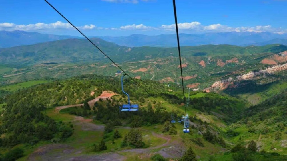 A cable car system in a mountainous area with lush greenery and distant mountains. 4