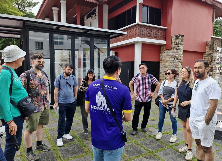 A group of people standing in front of a building with a glass facade and stone base. 3