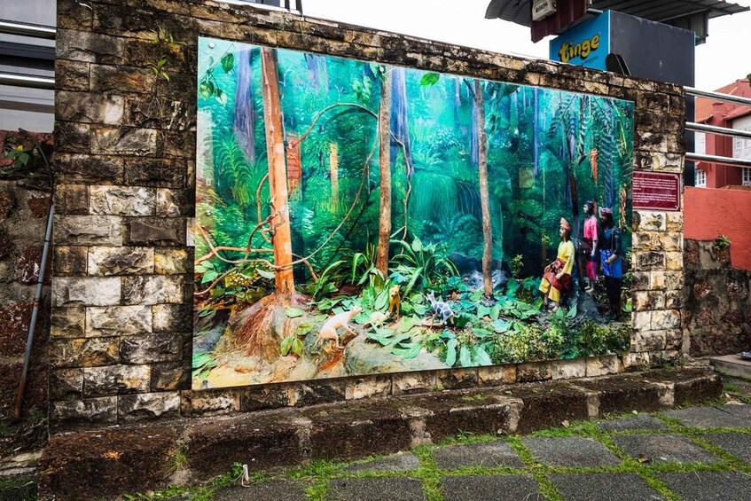 A mural of a forest scene with trees and foliage, a pathway, and a group of people. 4