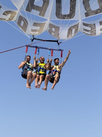 Three people suspended in mid-air by a parachute. 5