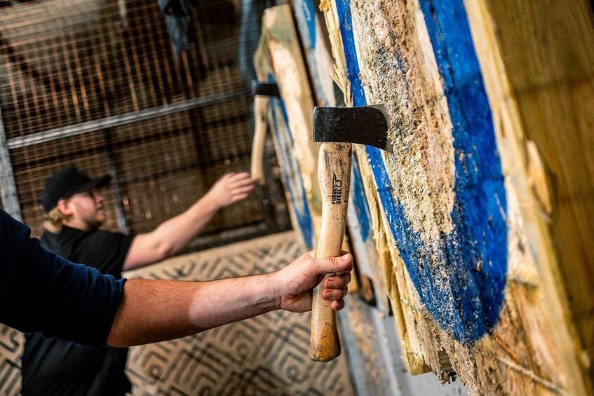 A person holding a hammer, preparing to strike a wooden post. 1