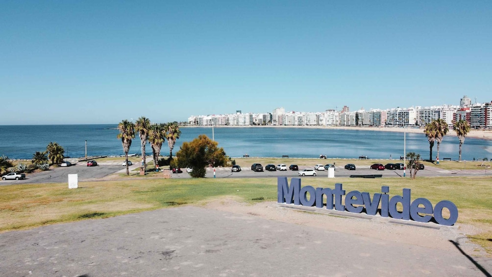 A coastal cityscape with a clear sky, palm trees, and a parking lot with cars. 4