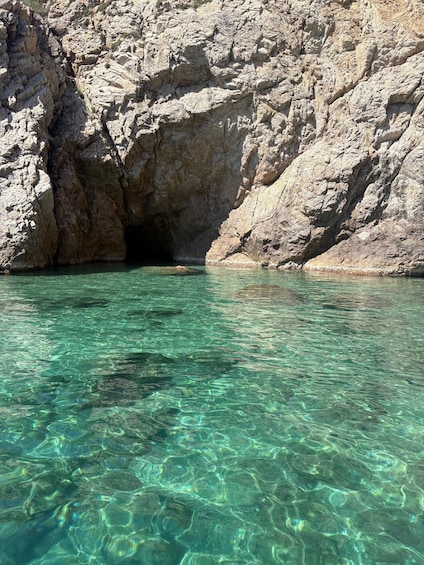 A rocky cave entrance with clear turquoise water. 2