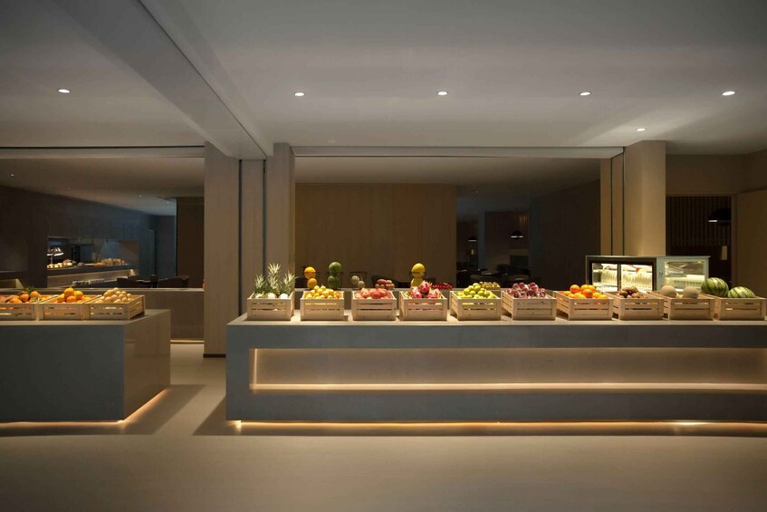 A modern food display with various fruits and vegetables in wooden crates. 2