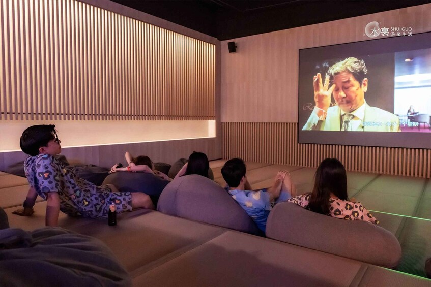 A group of people watching a movie in a modern cinema with a large screen and wooden paneling. 4