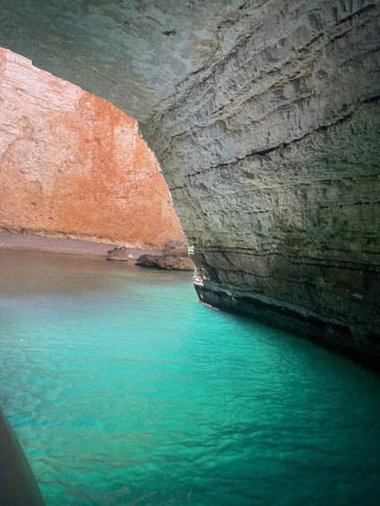 A cave with turquoise water and rocky walls. 2
