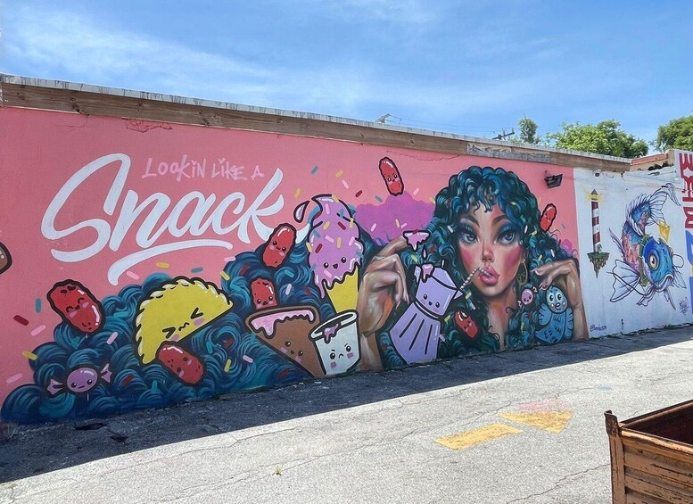 A colorful mural on a wall with the text 'Lookin' like a Snack' and various food illustrations. 5