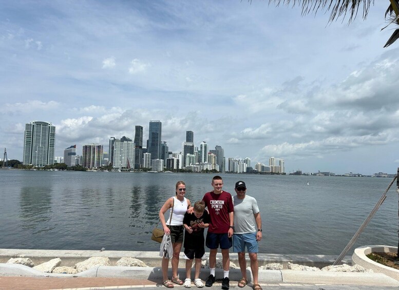 A group of people standing by a waterfront with a city skyline in the background. 4