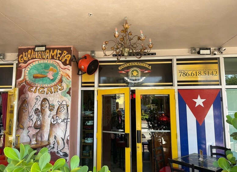 A storefront with a mural, a sign for Guantanamera cigars, and a Cuban flag. 3
