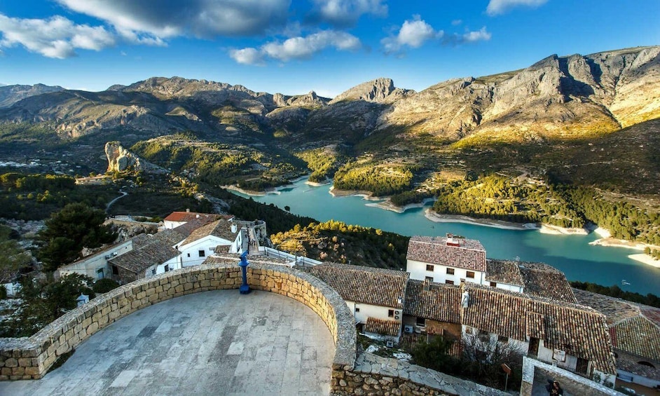 A mountainous landscape with a river, a stone bridge, and traditional buildings. 4