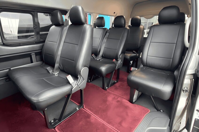 A vehicle's interior with black leather seats and red carpeting. 2