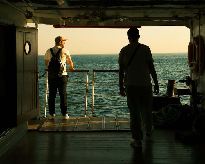 Two people on a boat deck overlooking the ocean. 3