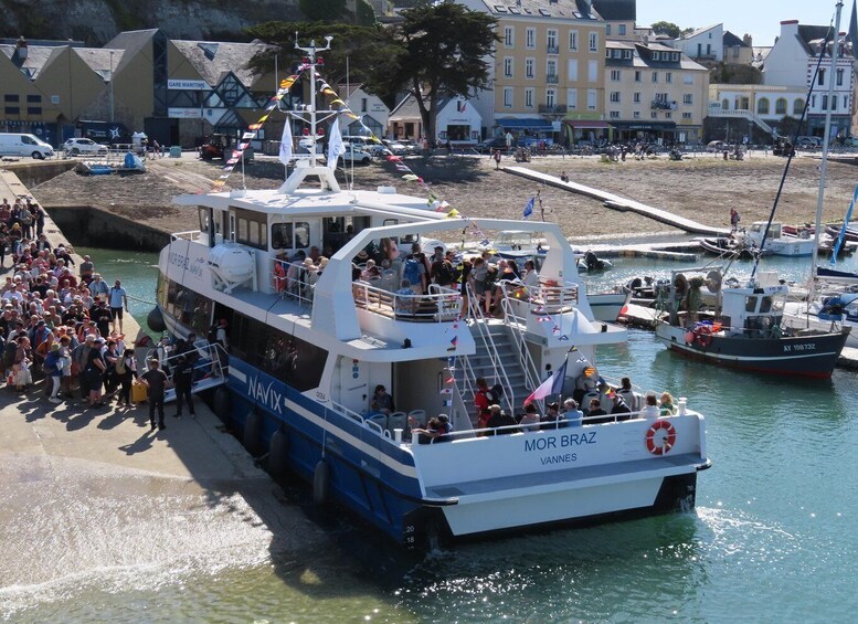 A ferry named 'MOR BRAZ' docked at a pier with people boarding and disembarking. 2