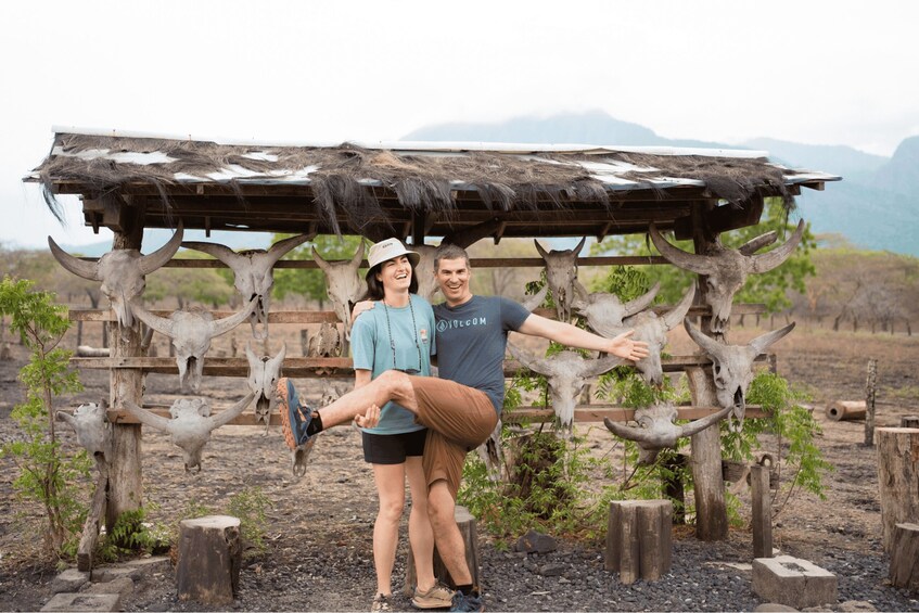 A couple posing in front of a structure with multiple cow skulls. 2