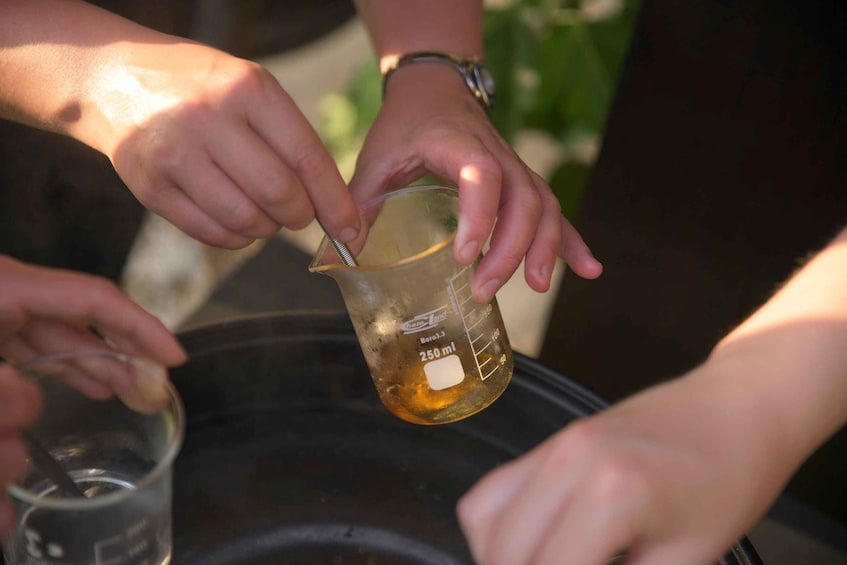 A person holding a beaker with a liquid, possibly conducting an experiment or demonstration. 3