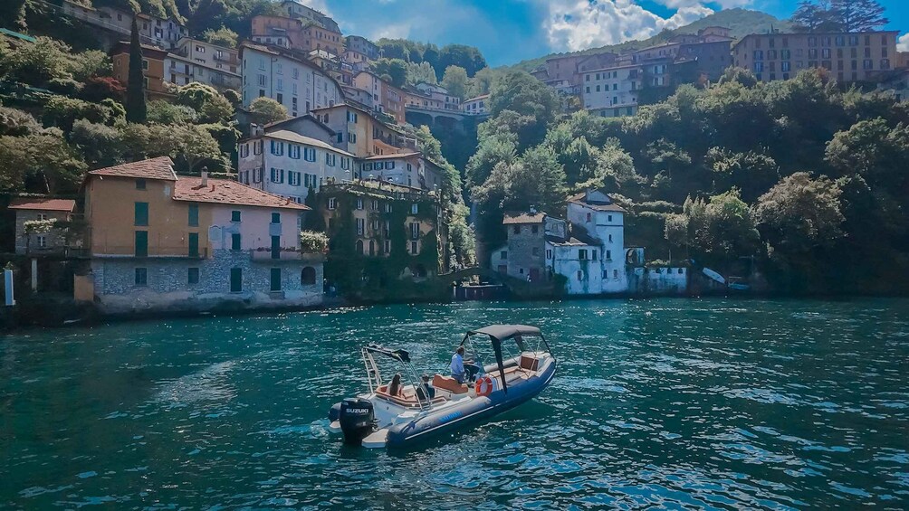 A boat on a calm river with buildings on the banks. 5
