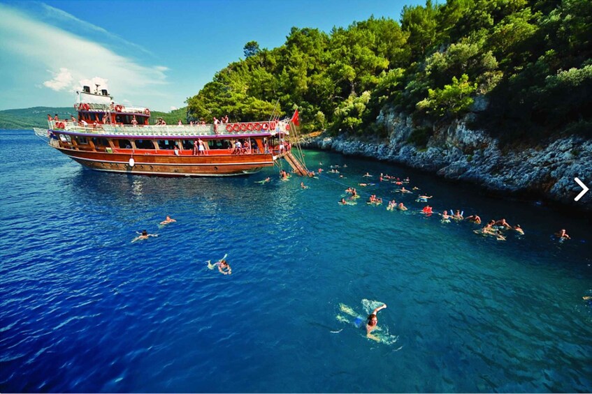 A boat with people swimming and snorkeling in the water. 4