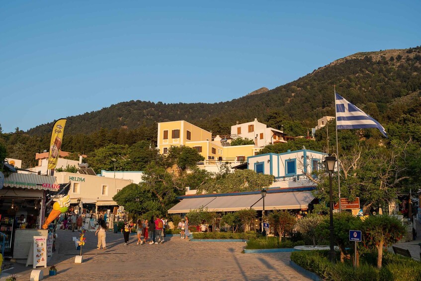 A coastal town with shops, a gelato stand, and a hill in the background. 4