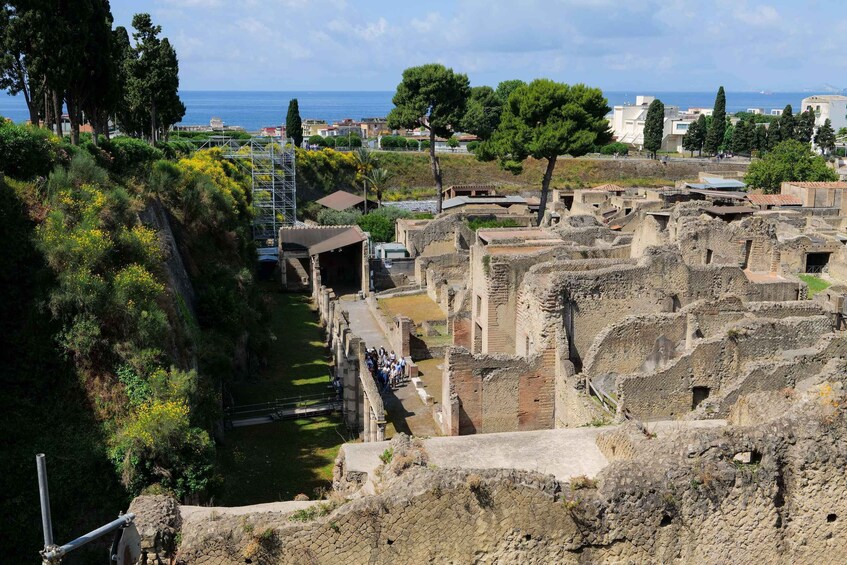 Ancient ruins with a view of the sea and modern buildings in the background. 2
