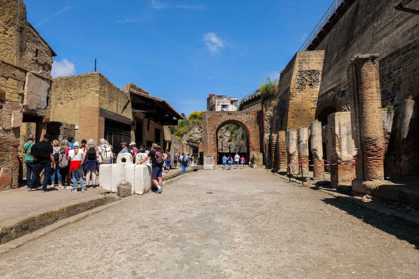 An ancient stone street with tourists walking. 3