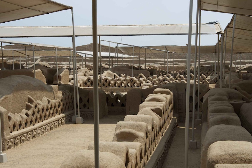 Un amplio espacio abierto con hileras de estructuras de piedra, posiblemente un sitio histórico o una excavación arqueológica. 5