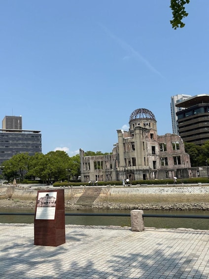 A historical building with a dome, surrounded by modern architecture and a river. 1