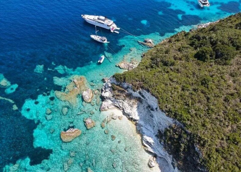 A coastal area with clear turquoise waters, rocky outcrops, and a boat anchored near the shore. 2