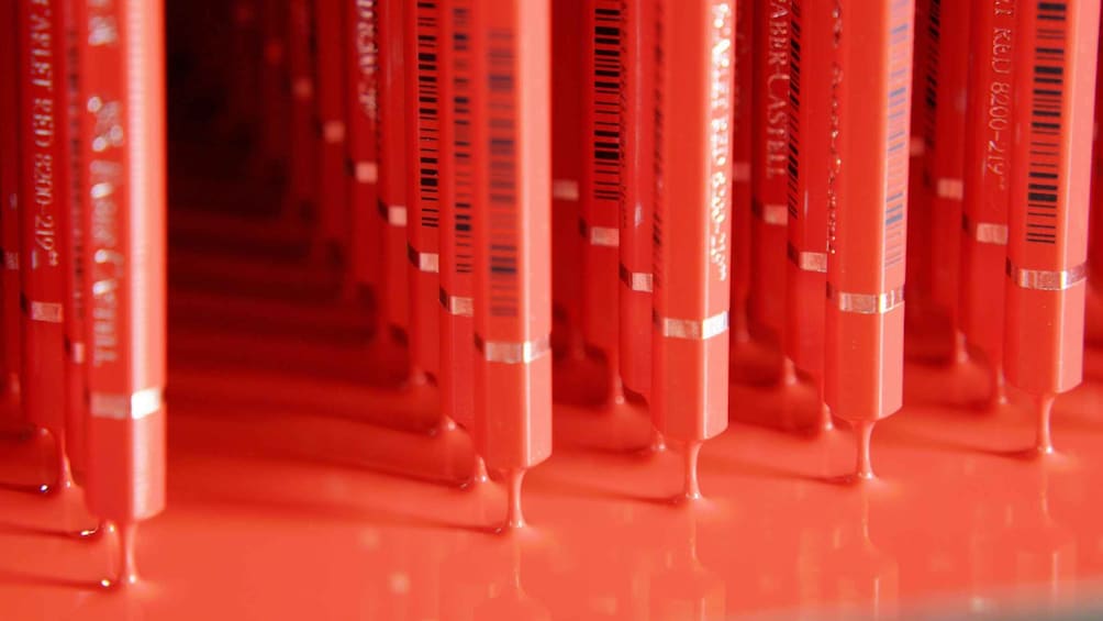 A row of red pencils with visible text on their bodies. 5
