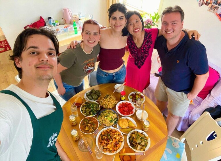 A group of people around a table with various dishes and drinks. 1