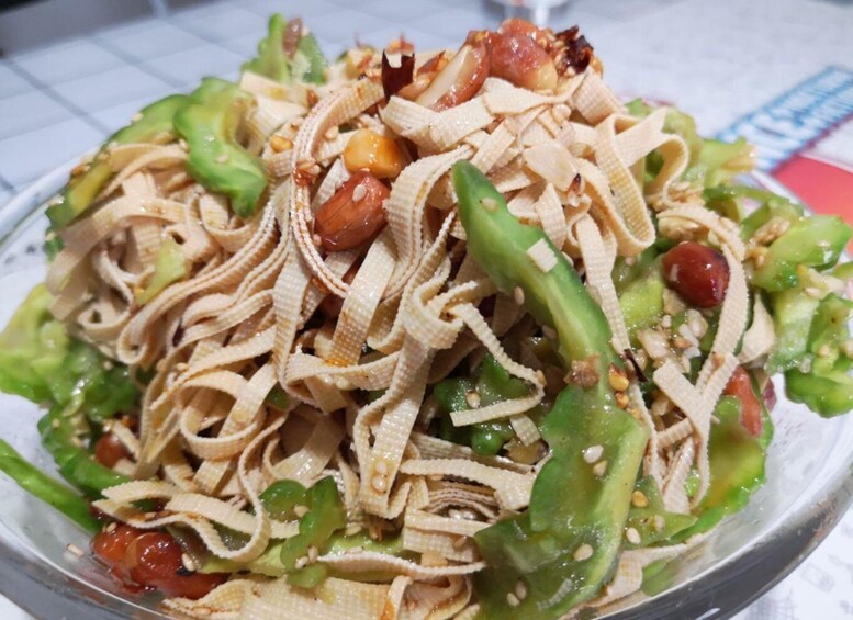 A salad with noodles, green vegetables, and peanuts. 4