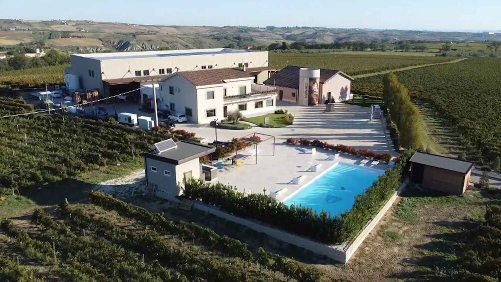 A large building complex with a swimming pool and surrounding greenery. 5