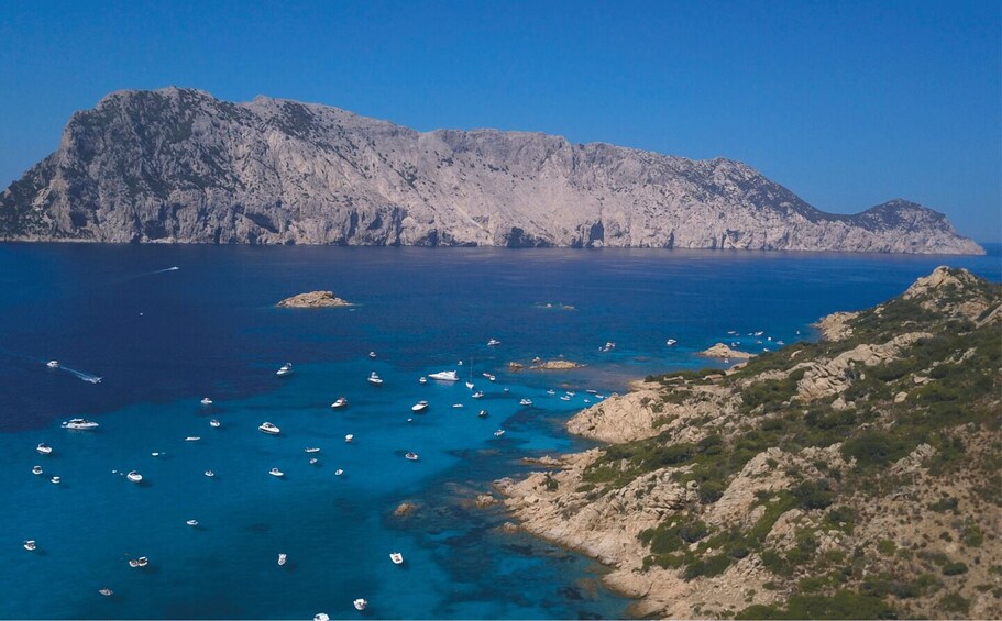 A coastal landscape with rocky cliffs and a clear blue sea. 1