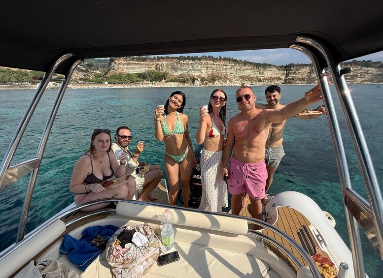 A group of people on a boat with a coastal landscape in the background. 4