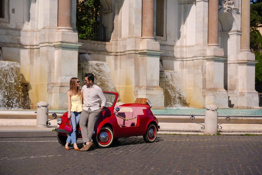 A red vintage car parked in front of a classical building with a fountain. 5