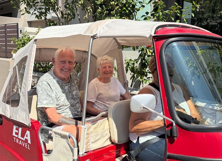 A red car with a canopy, labeled 'ELA Travel,' parked outdoors with trees in the background. 2