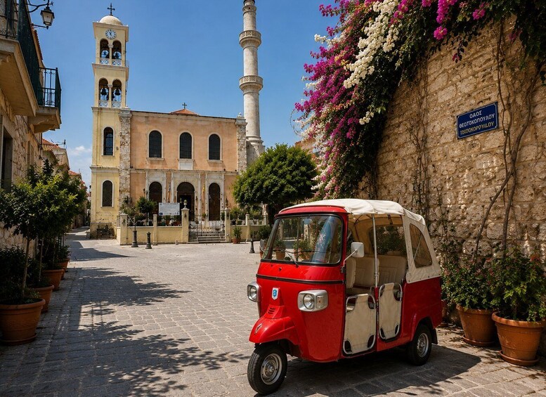 A red and white tuk-tuk parked on a cobblestone street, a historic building with a clock tower, and a stone wall with flowering plants. 4