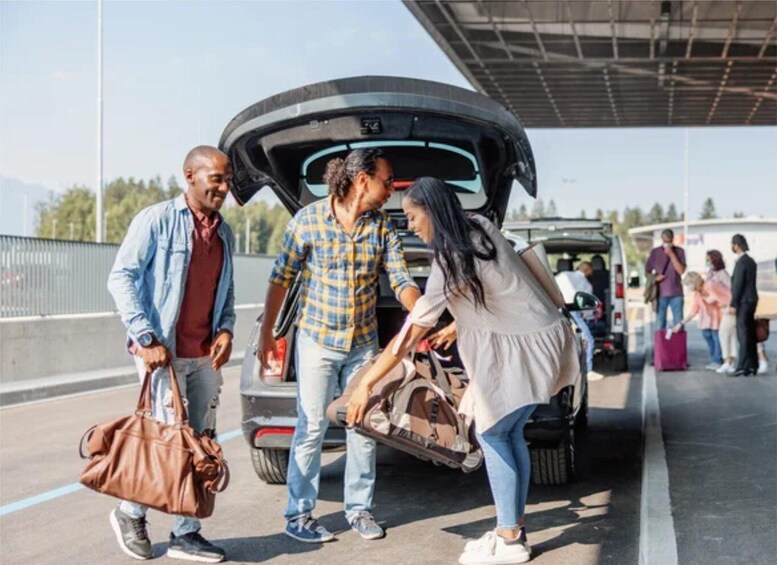 People loading luggage into the back of a car at a toll booth. 4