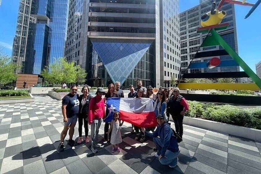 A group of people holding a flag in front of a modern building with a glass facade. 2