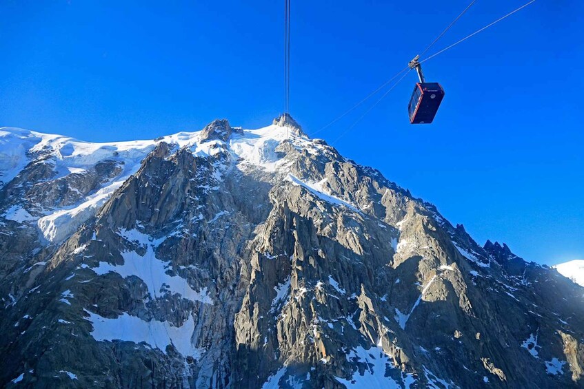 A mountain with a ski lift cable car ascending. 5