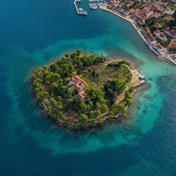 An aerial view of a small island with buildings and a dock. 3
