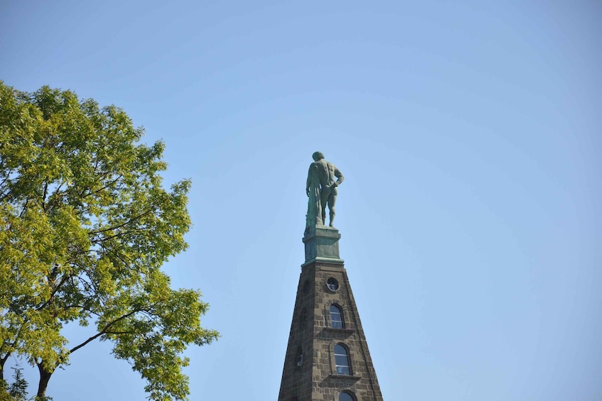 A statue atop a tower with arched windows. 3