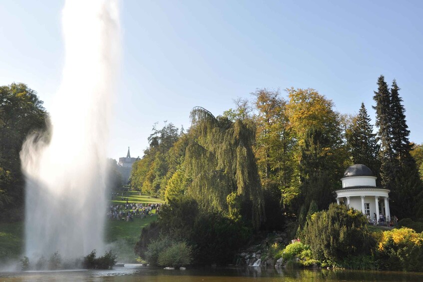 A fountain, a gazebo, and a hill with trees. 2