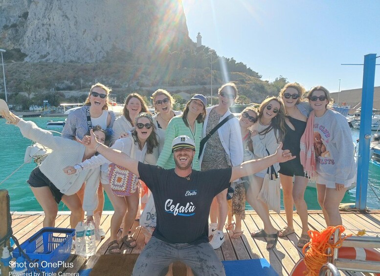 A group of people on a wooden dock with a mountainous backdrop. 4