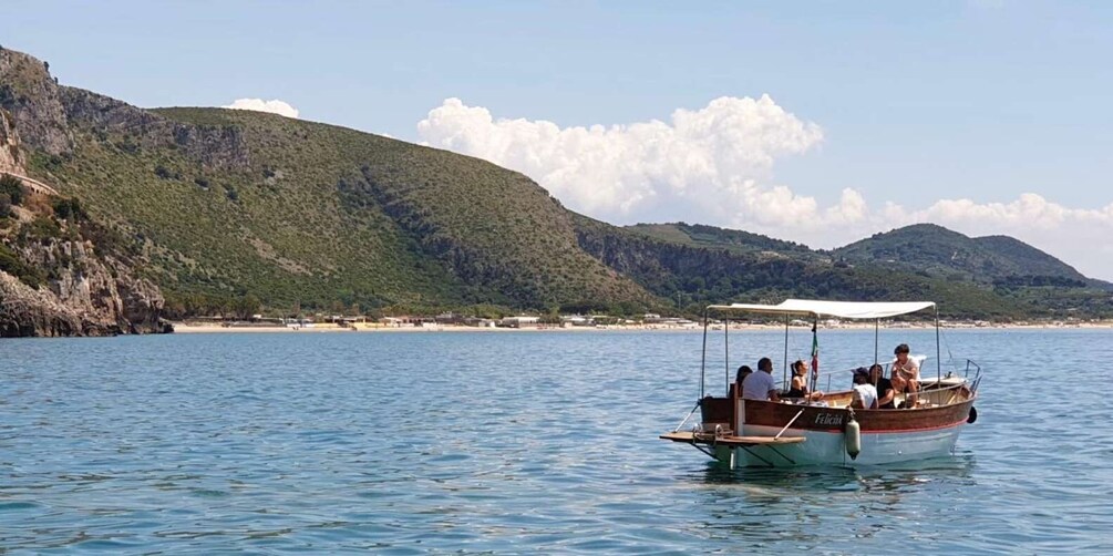A boat on calm water with a mountainous landscape in the background. 3