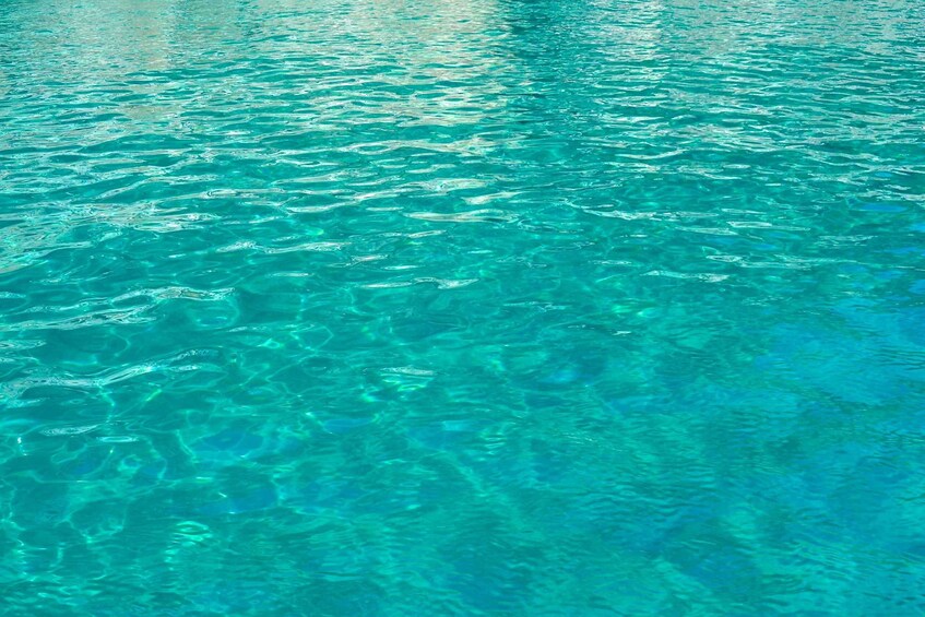 Clear turquoise water with visible ripples and reflections. 2