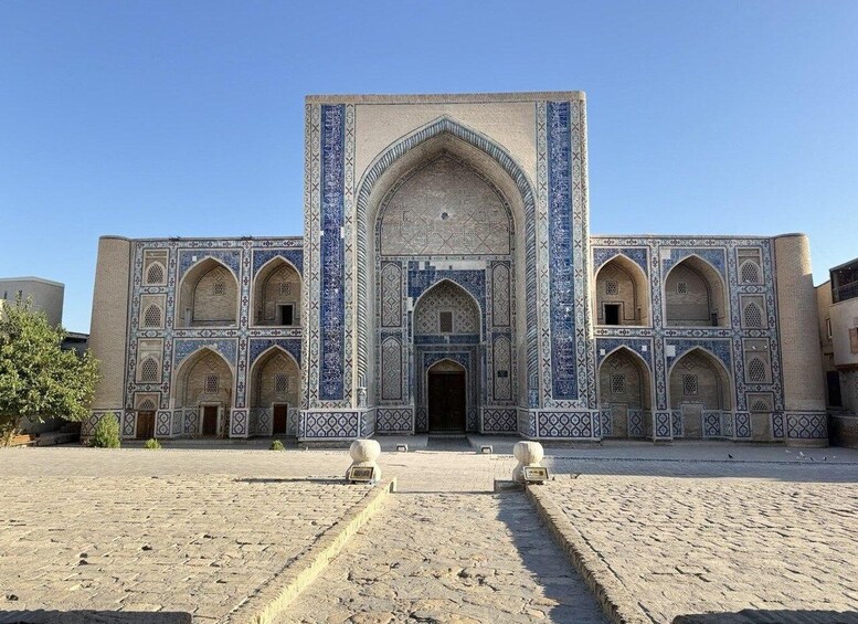 A historic building with intricate blue tile work and arched doorways. 5